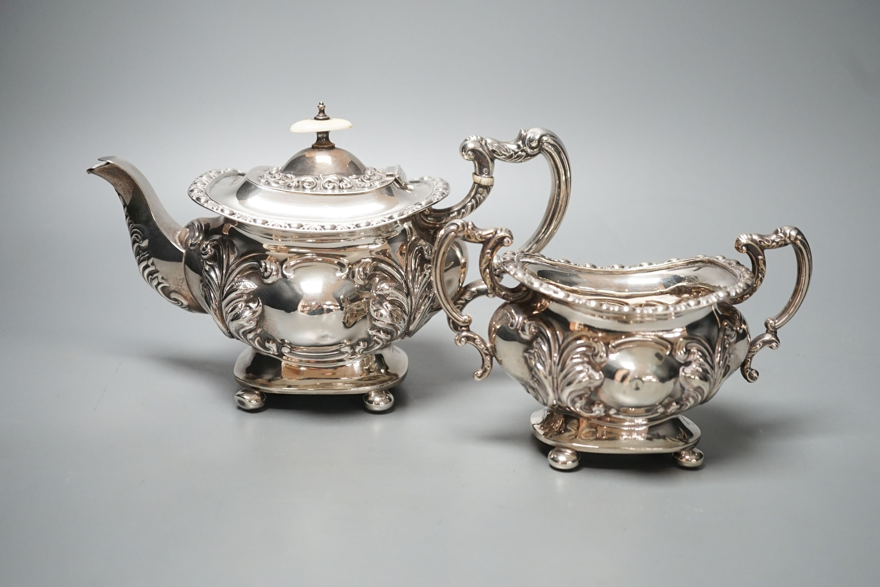 An Edwardian embossed silver teapot and matching sugar bowl, William Aitken, Chester, 1903, gross 21.5oz.